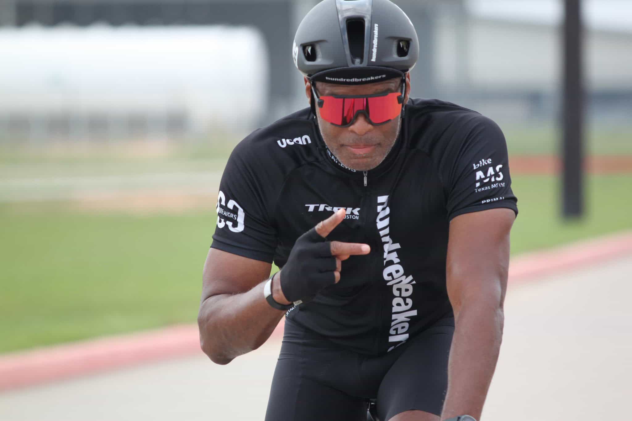 High-performance cyclist in Black Cycling Suit, riding on a track bike, demonstrating speed and focus.