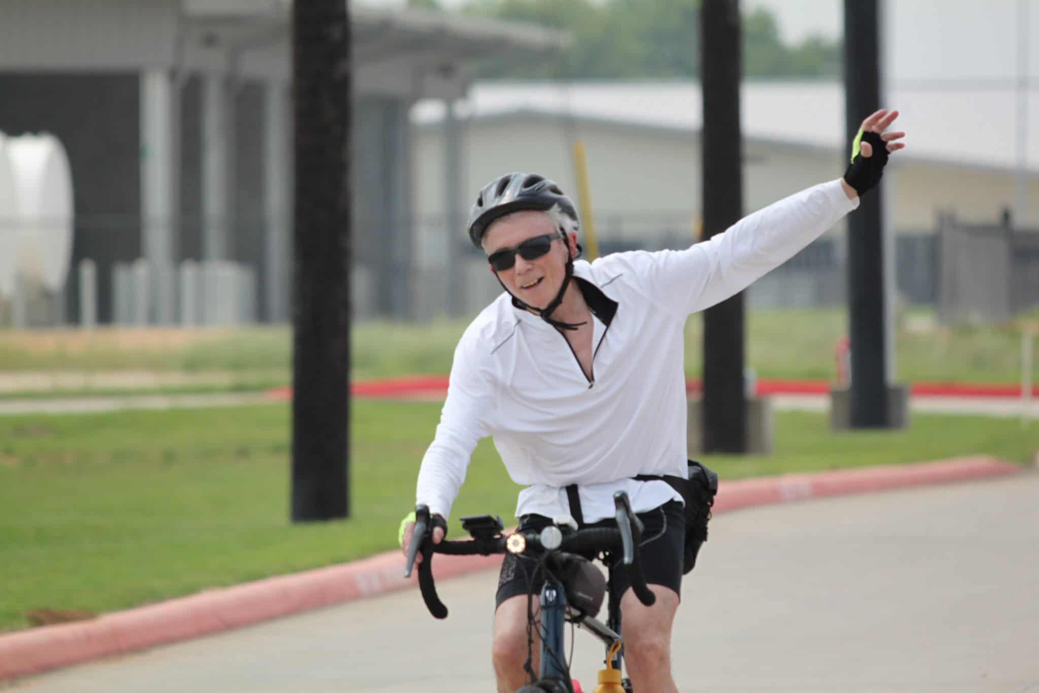 Bright man enjoying Bluebonnet Express cycling route, riding bike with enthusiasm.