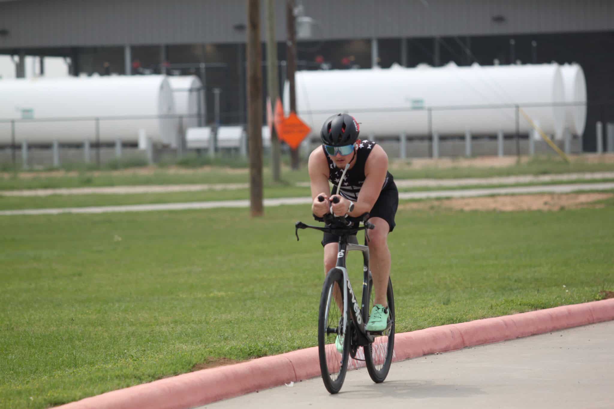 High-performance cyclist on a road bike during a race, wearing helmet and sports gear.