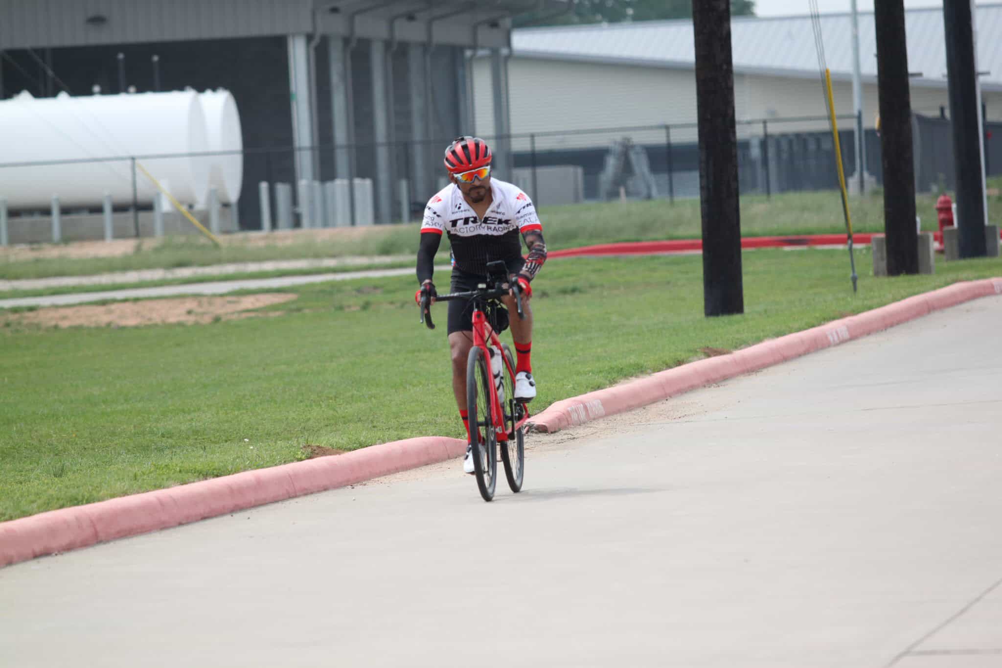 High-performance cyclist riding a Trek bike outdoors in a scenic area.