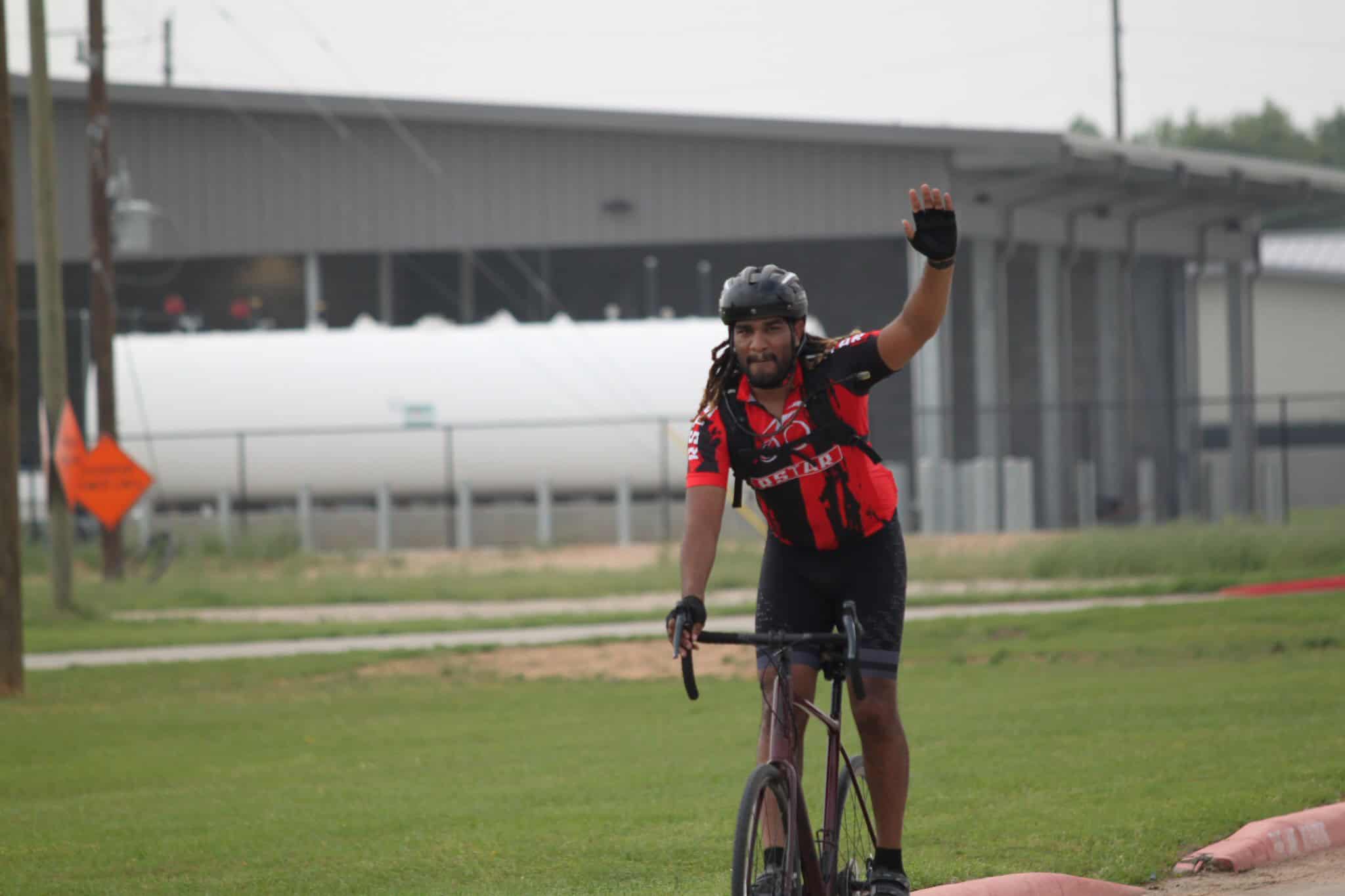 Bike racer waving at the finish line during Bluebonnet Express cycling event.