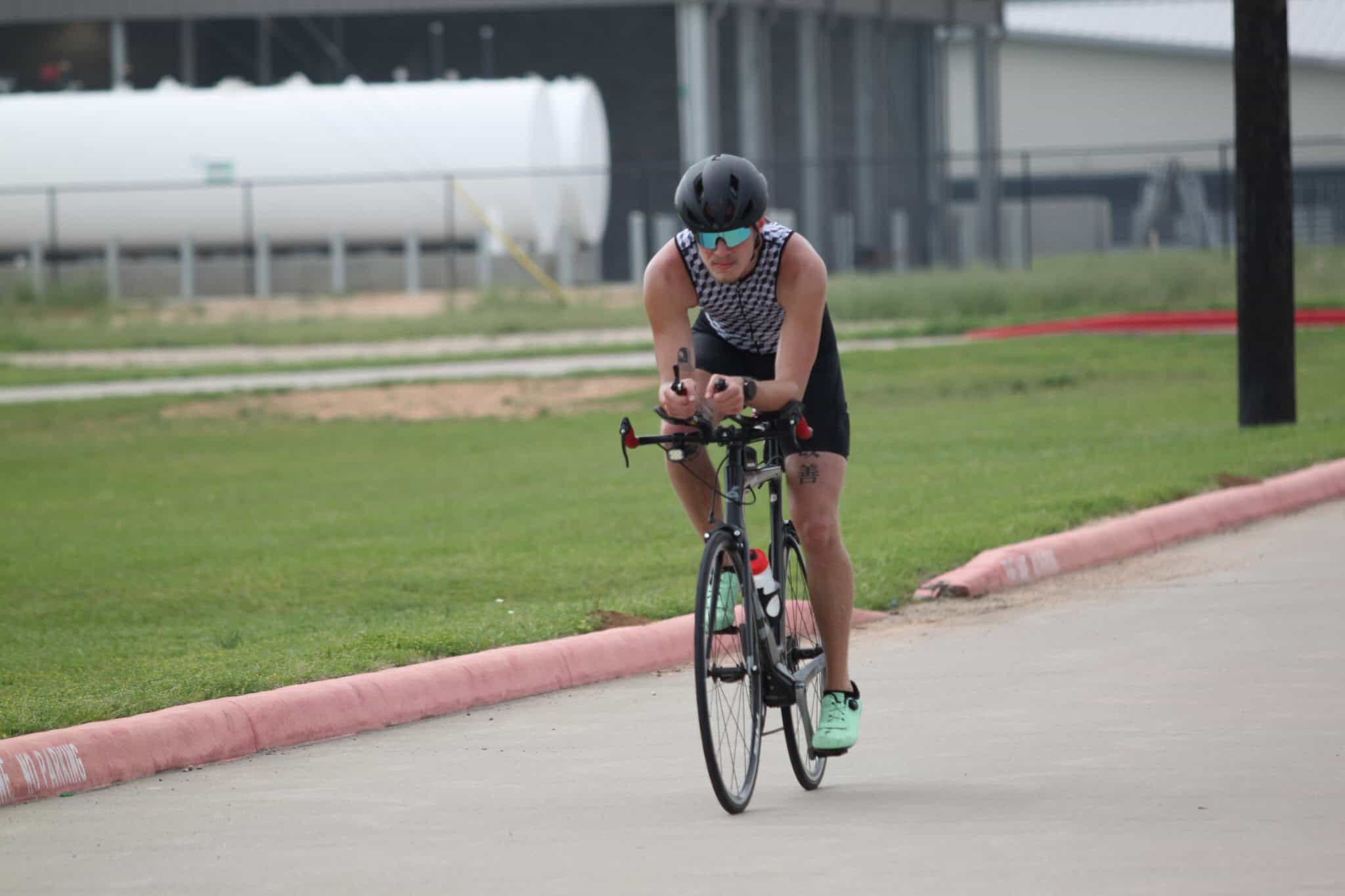 High-performance cyclist riding on a gravel trail in a triathlon-style race.