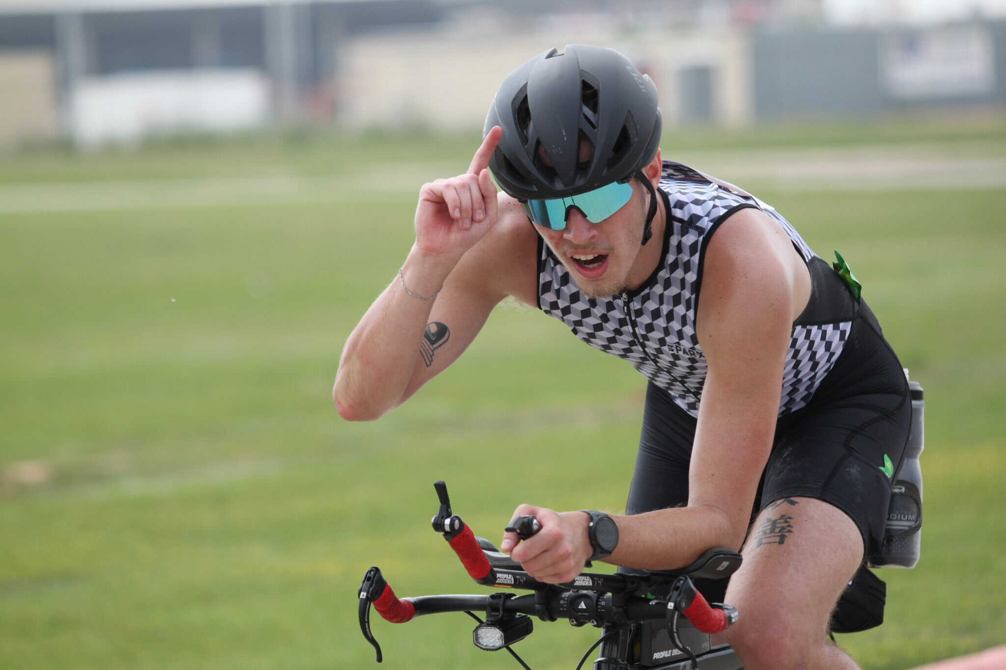 Man wearing helmet and sunglasses riding a bicycle outdoors for Bluebonnet Express event.
