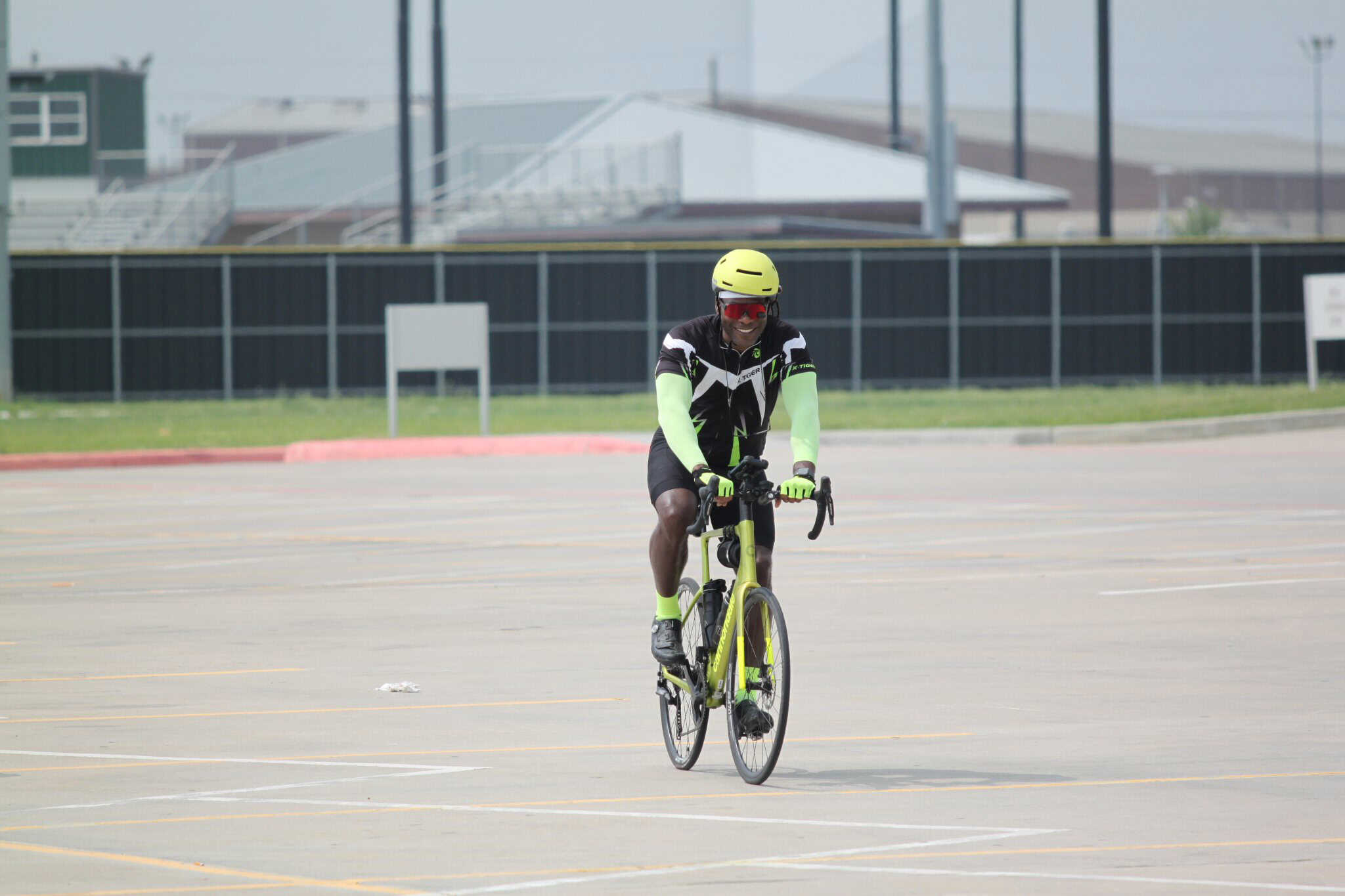 Bright yellow bike with rider on outdoor cycling track, promoting Bluebonnet Express bike services.
