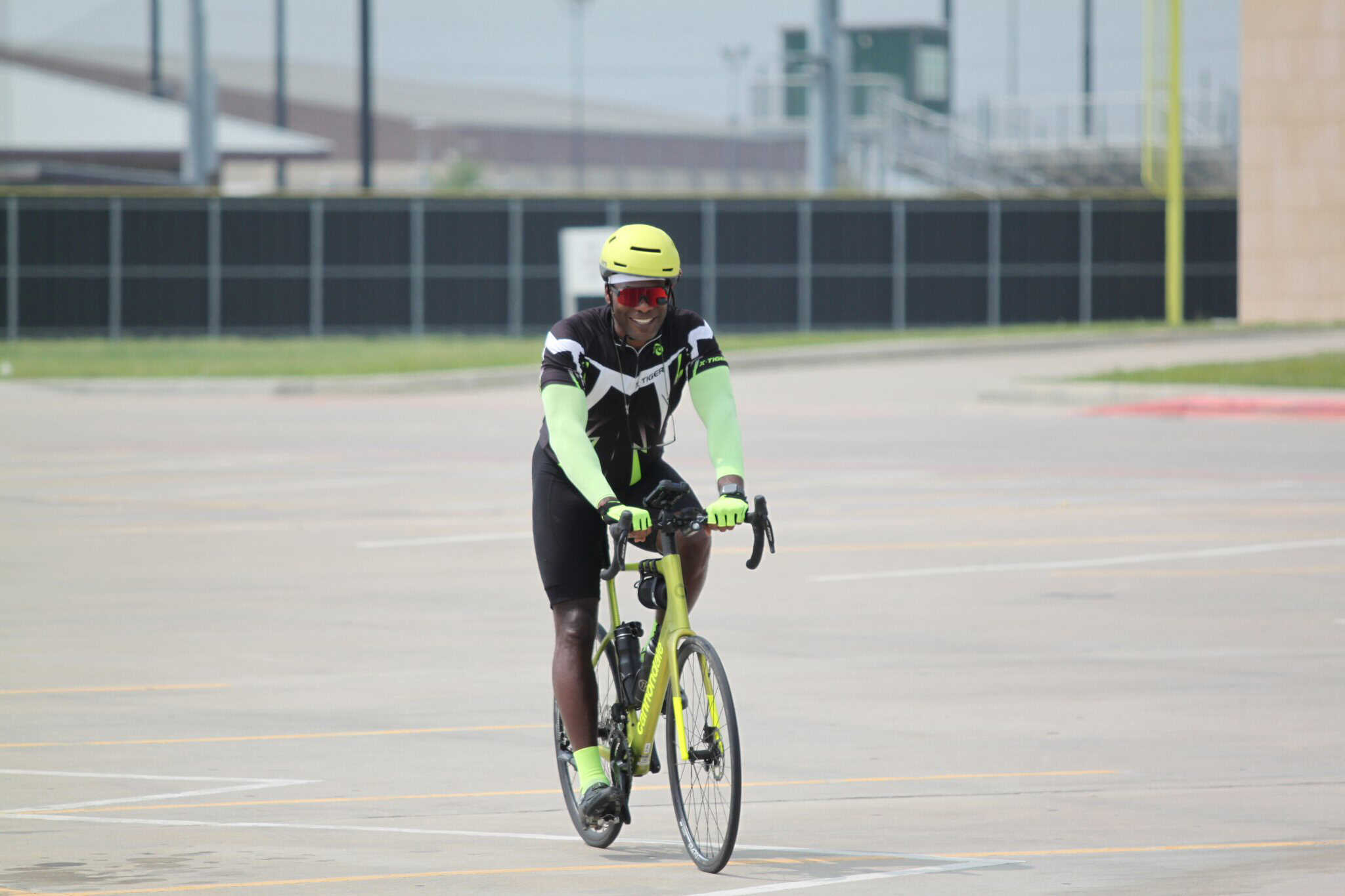 Bright yellow and black bike with safety gear riding in a parking lot, promoting Bluebonnet Express bike service.
