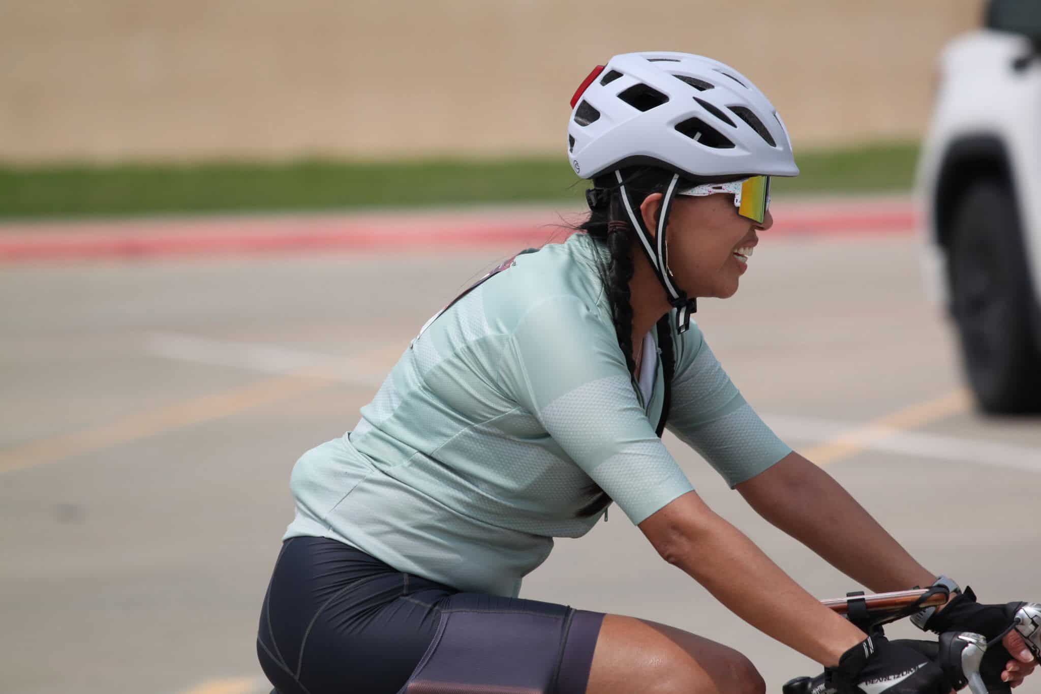 Bright woman cycling with helmet and sunglasses in Bluebonnet Express bike event.