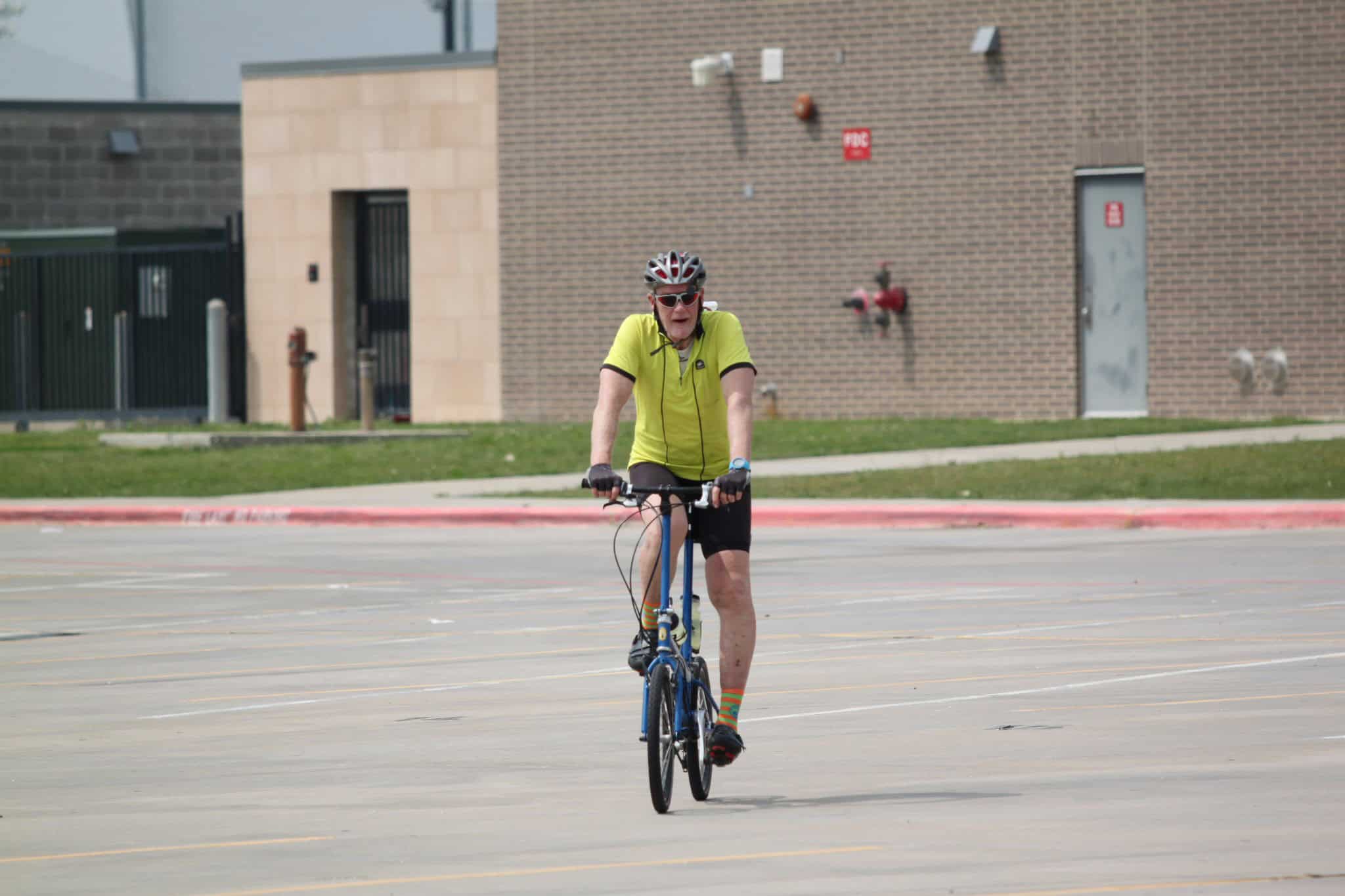 Vibrant cyclist riding a bike in an urban area during daytime.