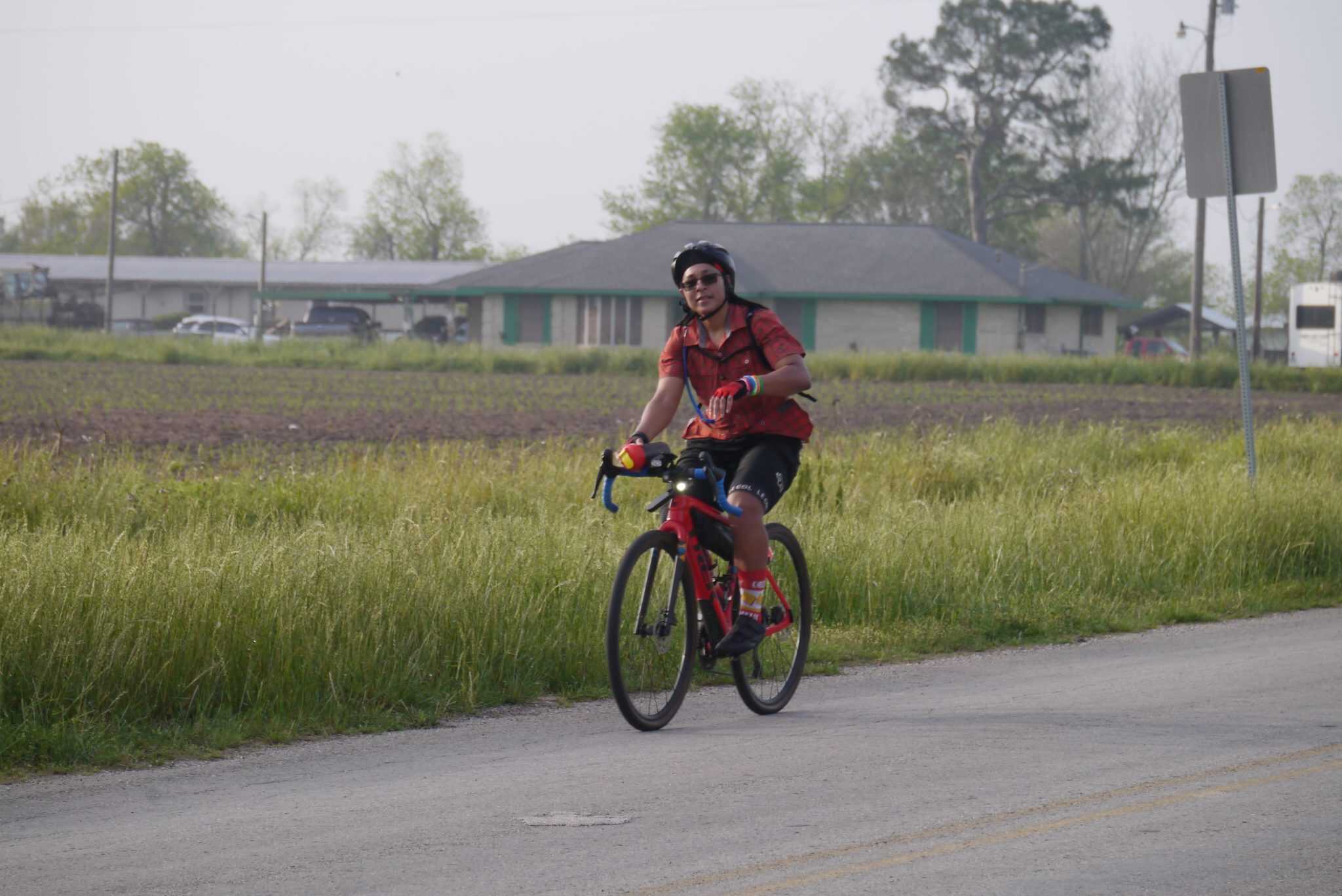 Brightred Trek bike rider on a rural road, promoting Bluebonnet Express cycling service.