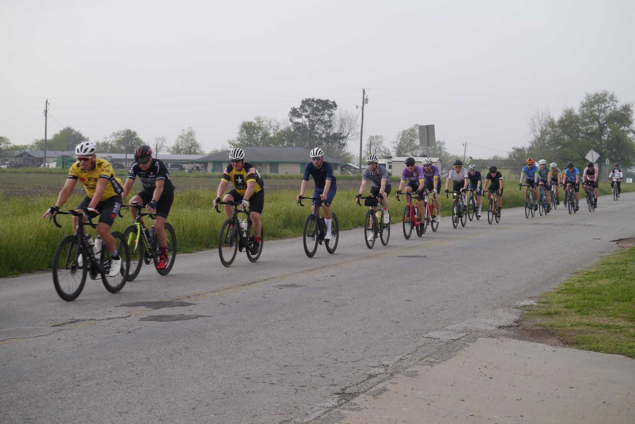 Cycling event featuring multiple cyclists riding on a rural road, promoting Bluebonnet Express bike tours.