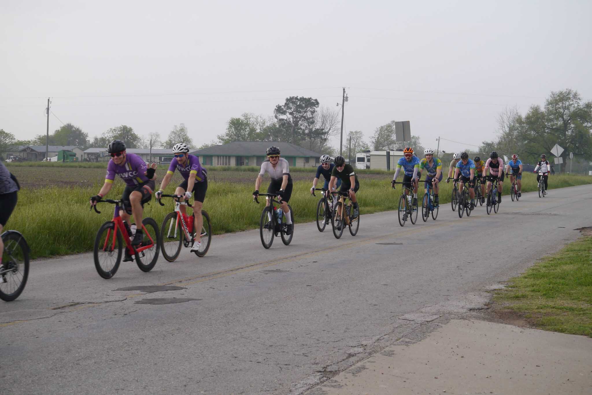 Cyclists riding on a rural road during the Bluebonnet Express event, promoting community cycling and outdoor activity.