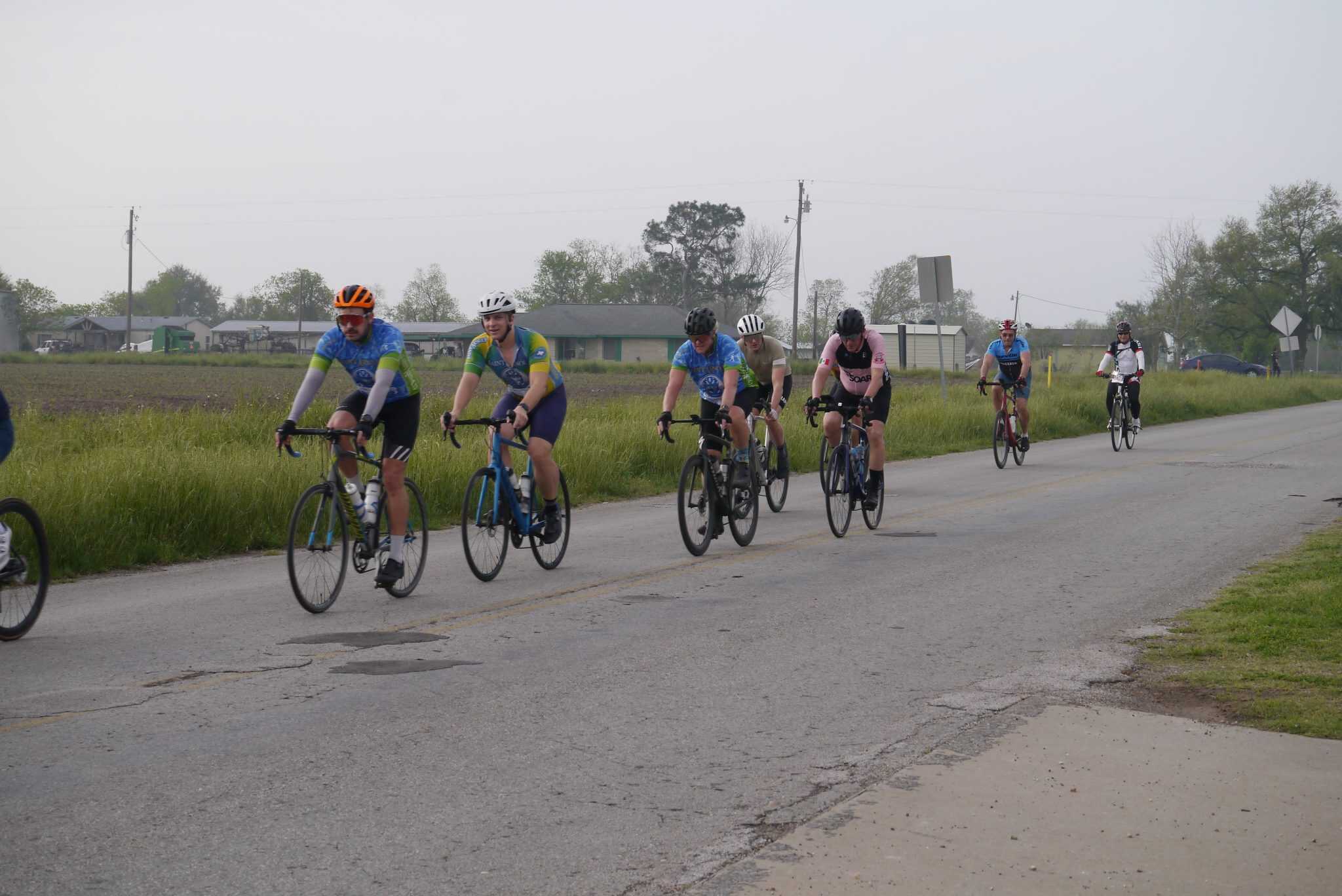 Cyclists riding on a rural road during Bluebonnet Express event in Texas for community cycling.