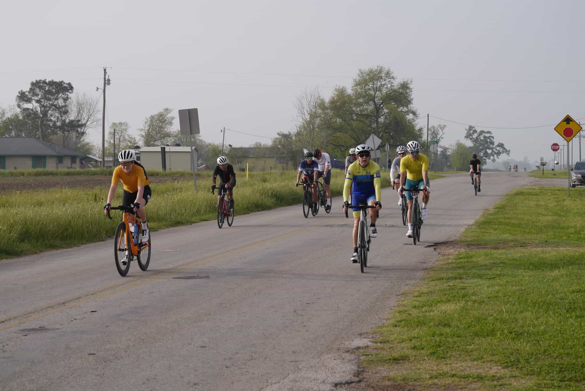 Cyclists riding on a rural road, part of the Bluebonnet Express cycling event.