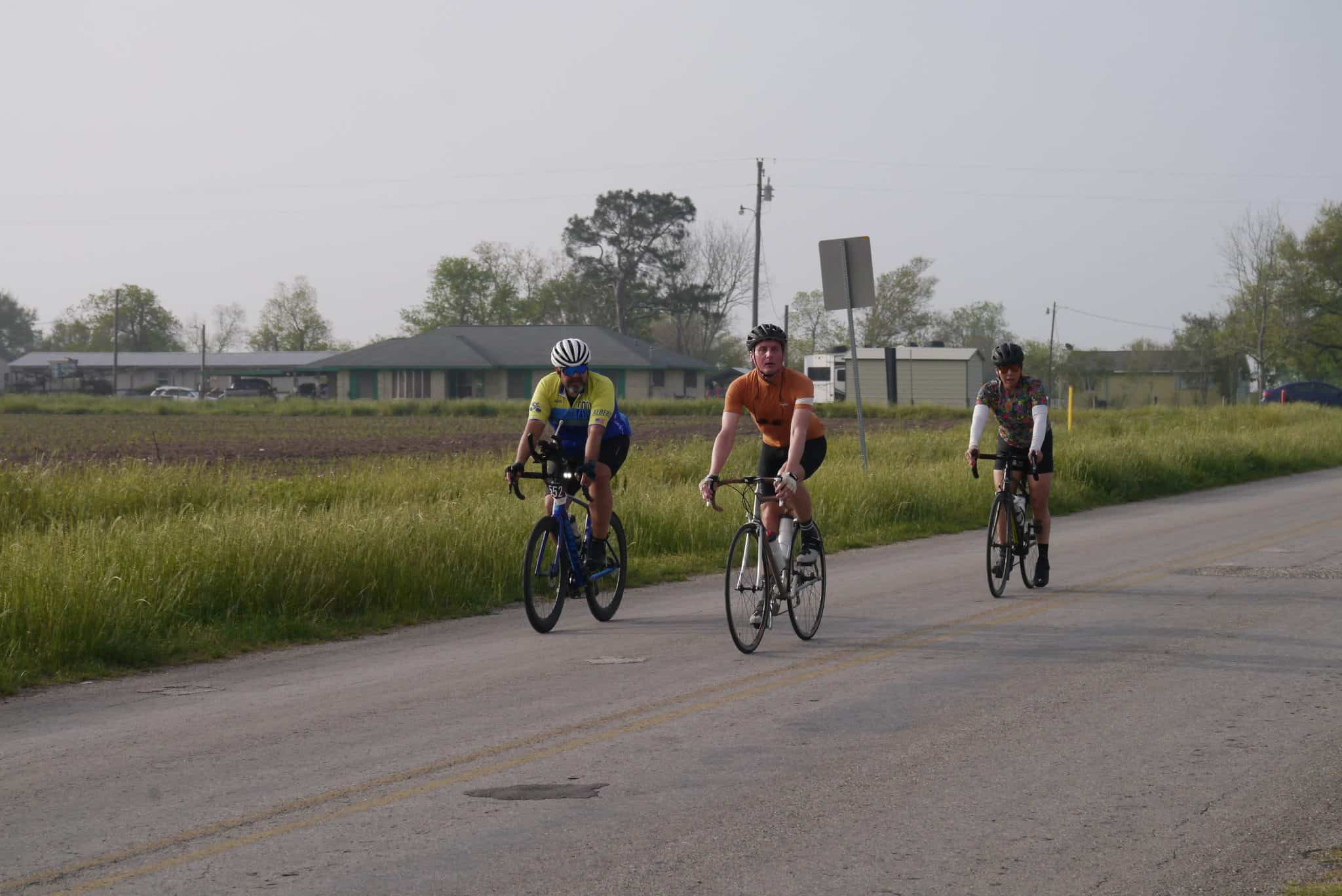 Cyclists riding on a rural road, promoting outdoor cycling with Bluebonnet Express bike services.
