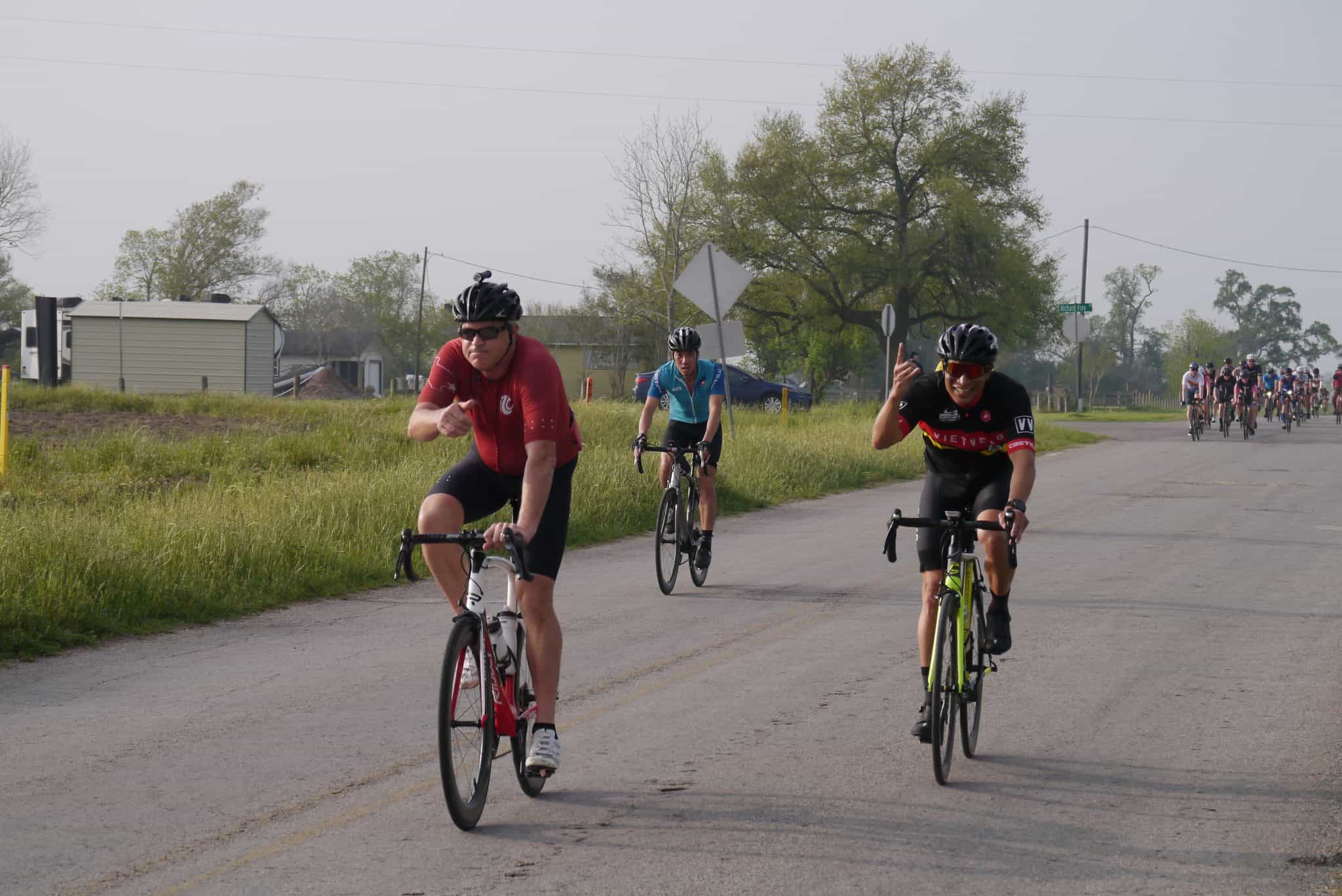 Bicycle riders participating in Bluebonnet Express cycling event on scenic rural road.