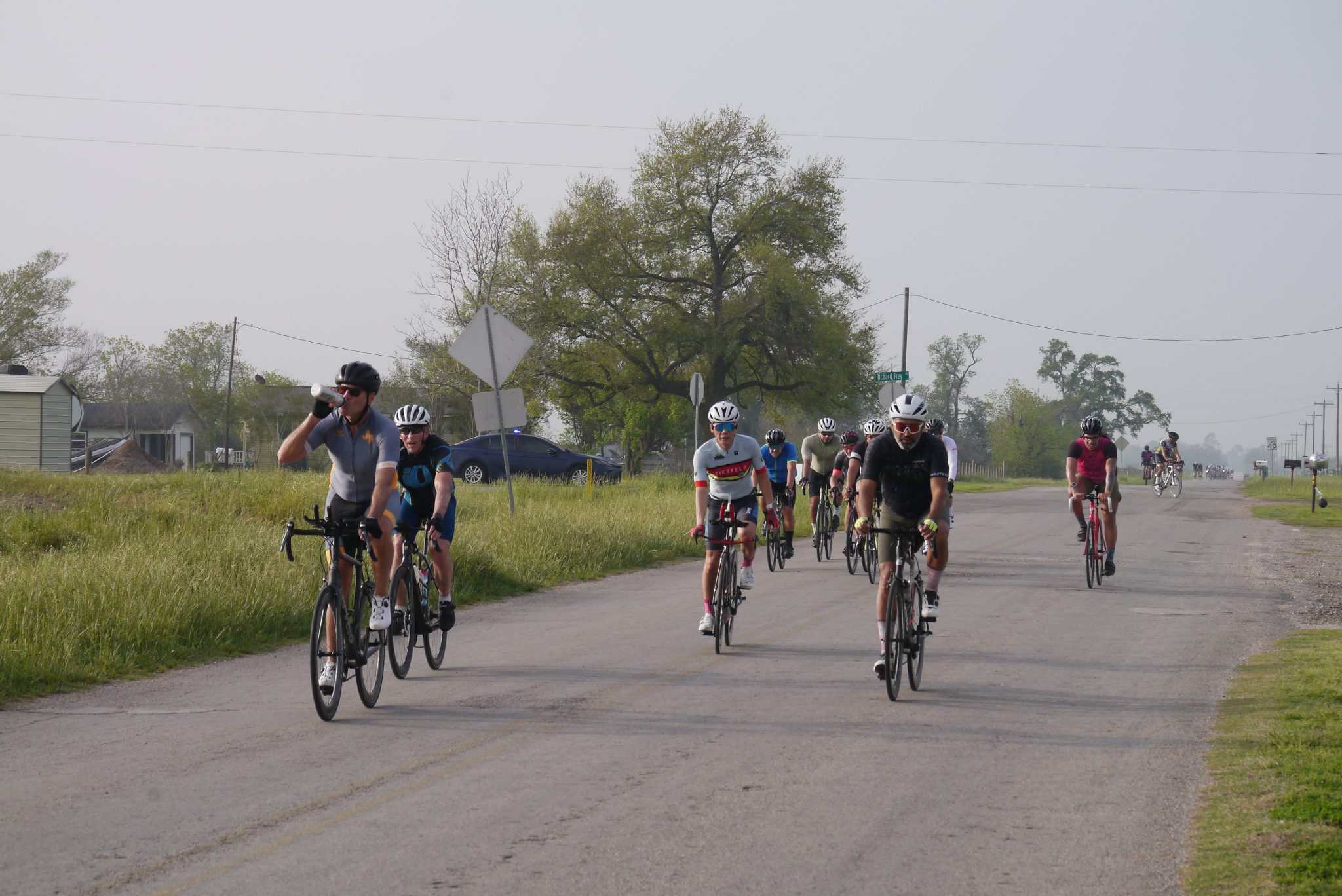 Cyclists riding on a rural road during the Bluebonnet Express event, enjoying outdoor cycling adventure.