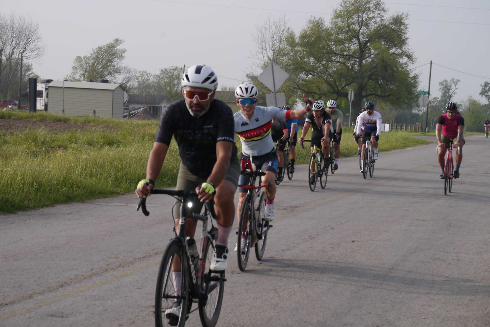 Spectacular group of cyclists riding on rural road during Bluebonnet Express event, promoting cycling and fitness.