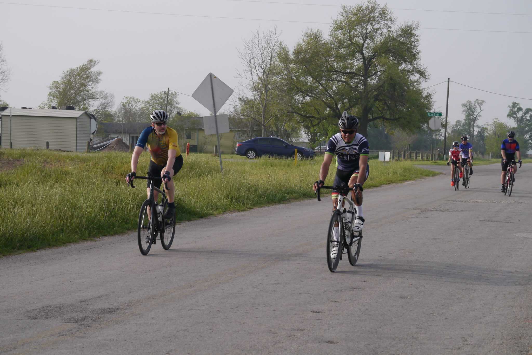 Cyclists on a rural road during a cycling event at Bluebonnet Express, showcasing scenic bike rides and outdoor recreation.