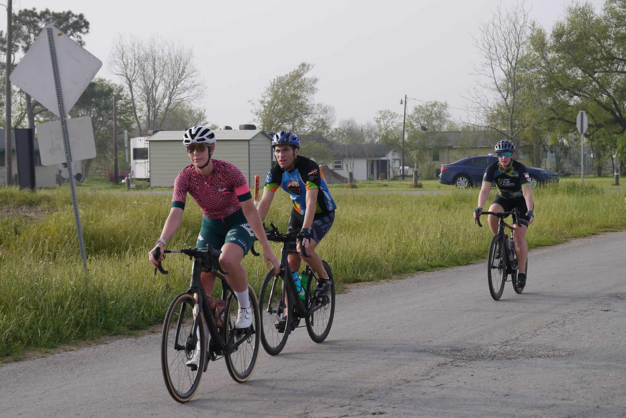 Brightly dressed cyclists riding along a rural road in the Bluebonnet Express event.