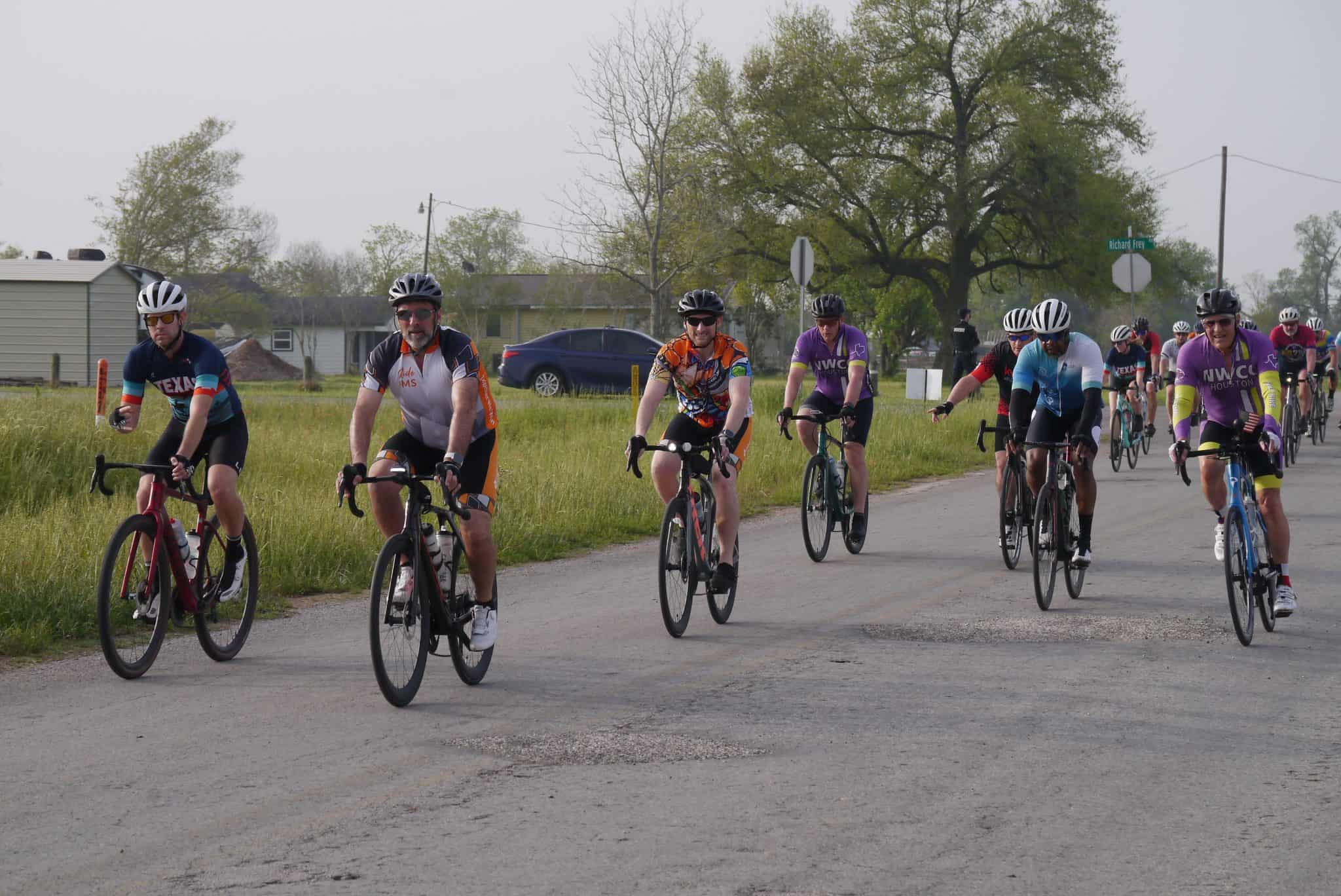 Cyclists participating in the Bluebonnet Express cycling event on a rural road.
