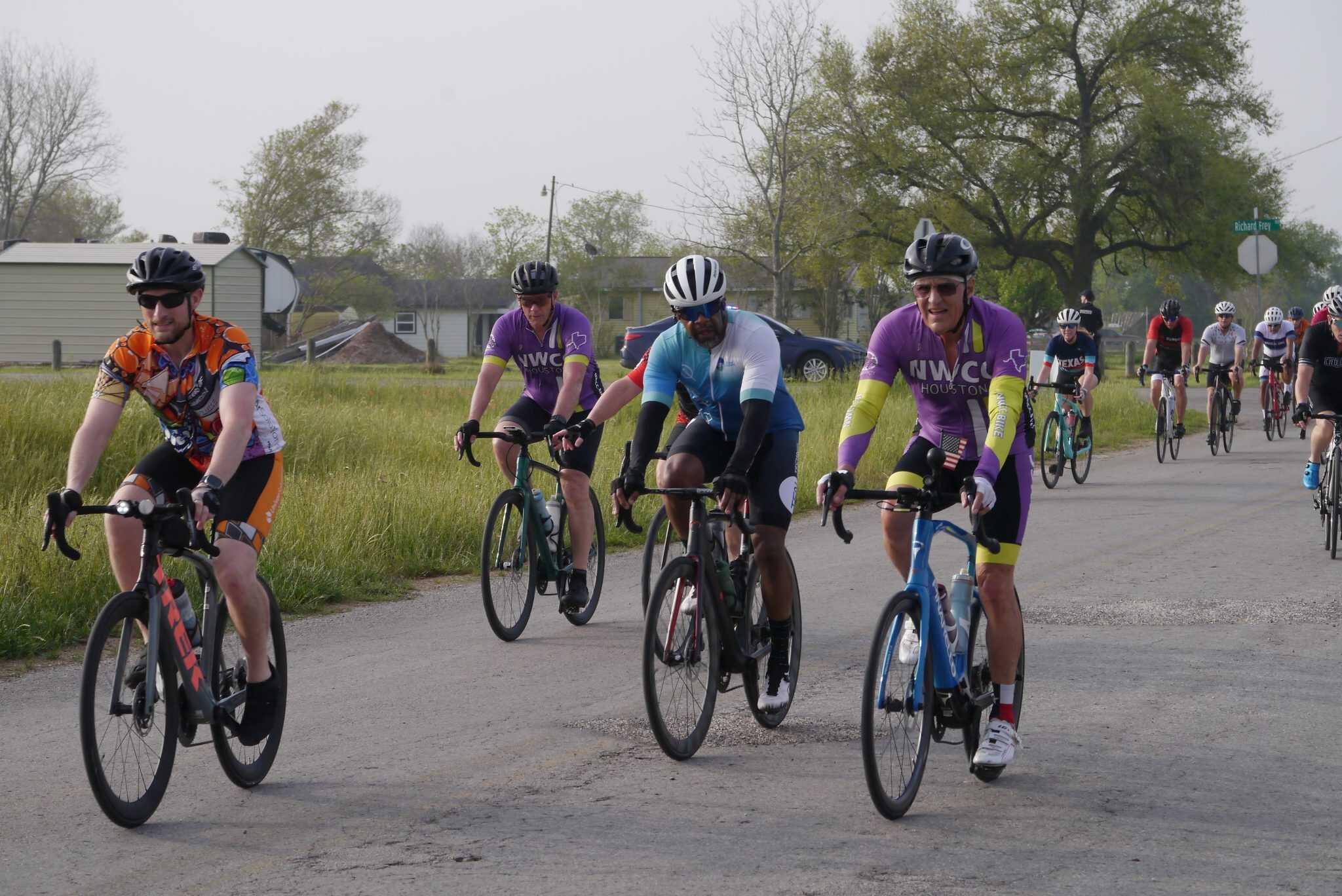 Cyclists riding during Bluebonnet Express bike race event in Texas, showcasing vibrant cycling jerseys and outdoor scenery.