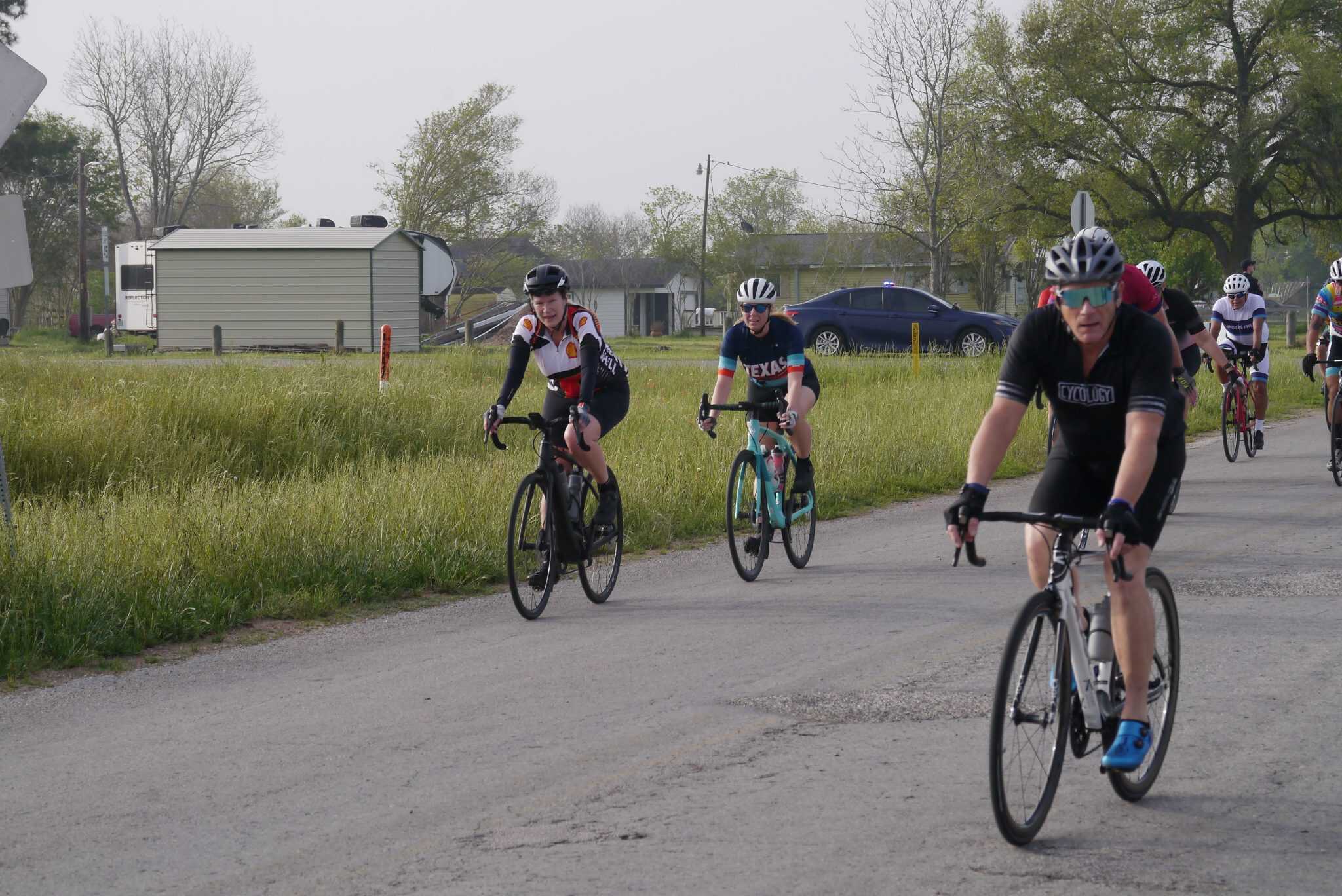 Bicycle riders participating in the Bluebonnet Express cycling event on a rural road.