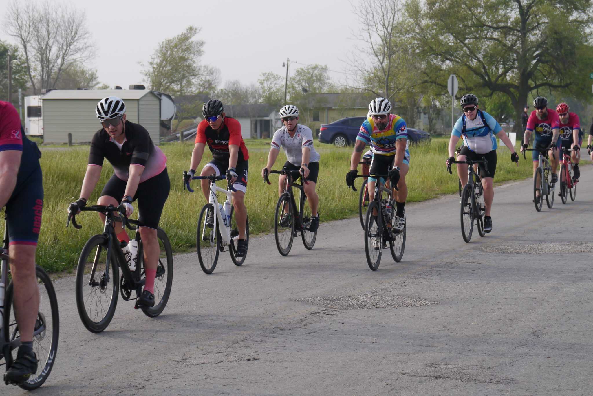 Cyclists participating in the Bluebonnet Express bike race on a rural road during daytime.