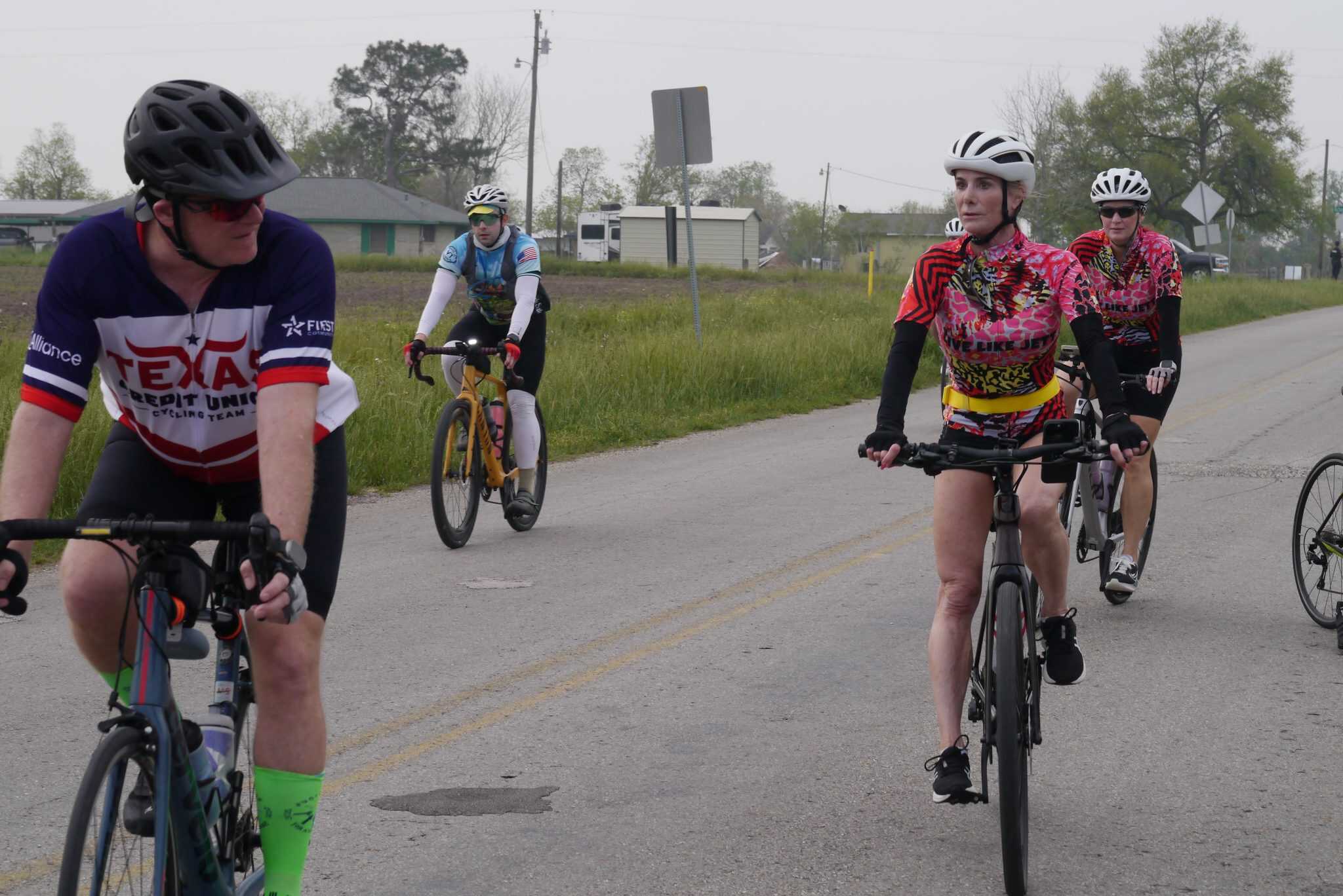 Velo riders participating in Bluebonnet Express cycling event on rural Texas road.
