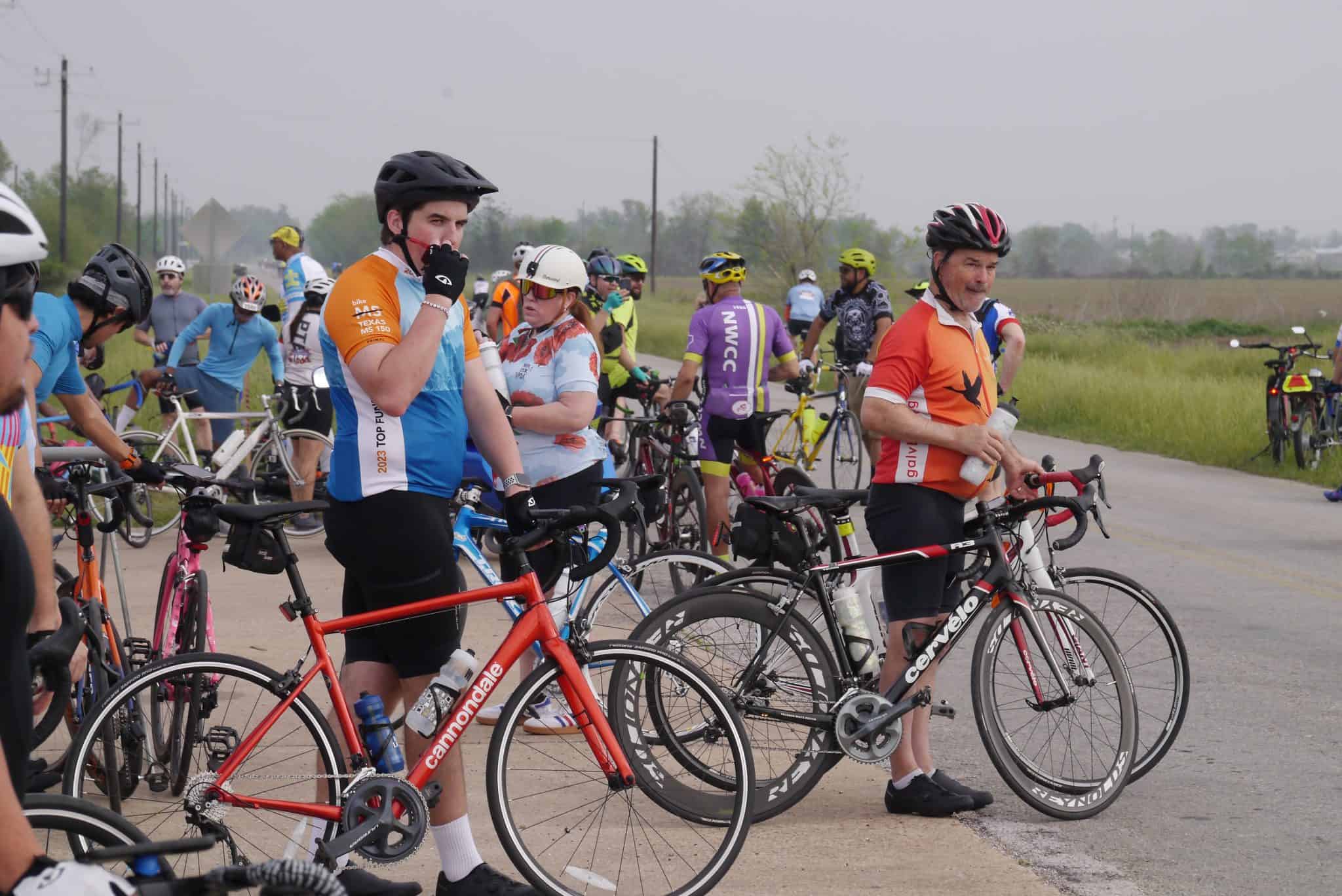 Vibrant group of cyclists at Bluebonnet Express cycling event on scenic rural road 100+ cyclists gather for community cycling event, promoting fitness and outdoor fun.
