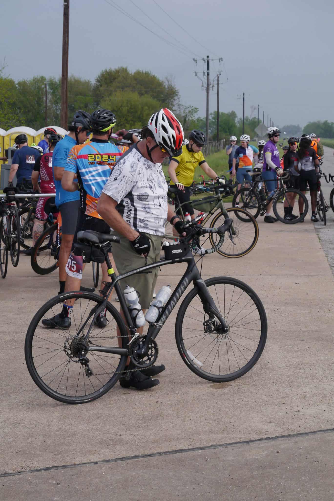 Bright cyclist with bike at Bluebonnet Express event, outdoor charity ride, Texas bike ride, biking race, cycling event.