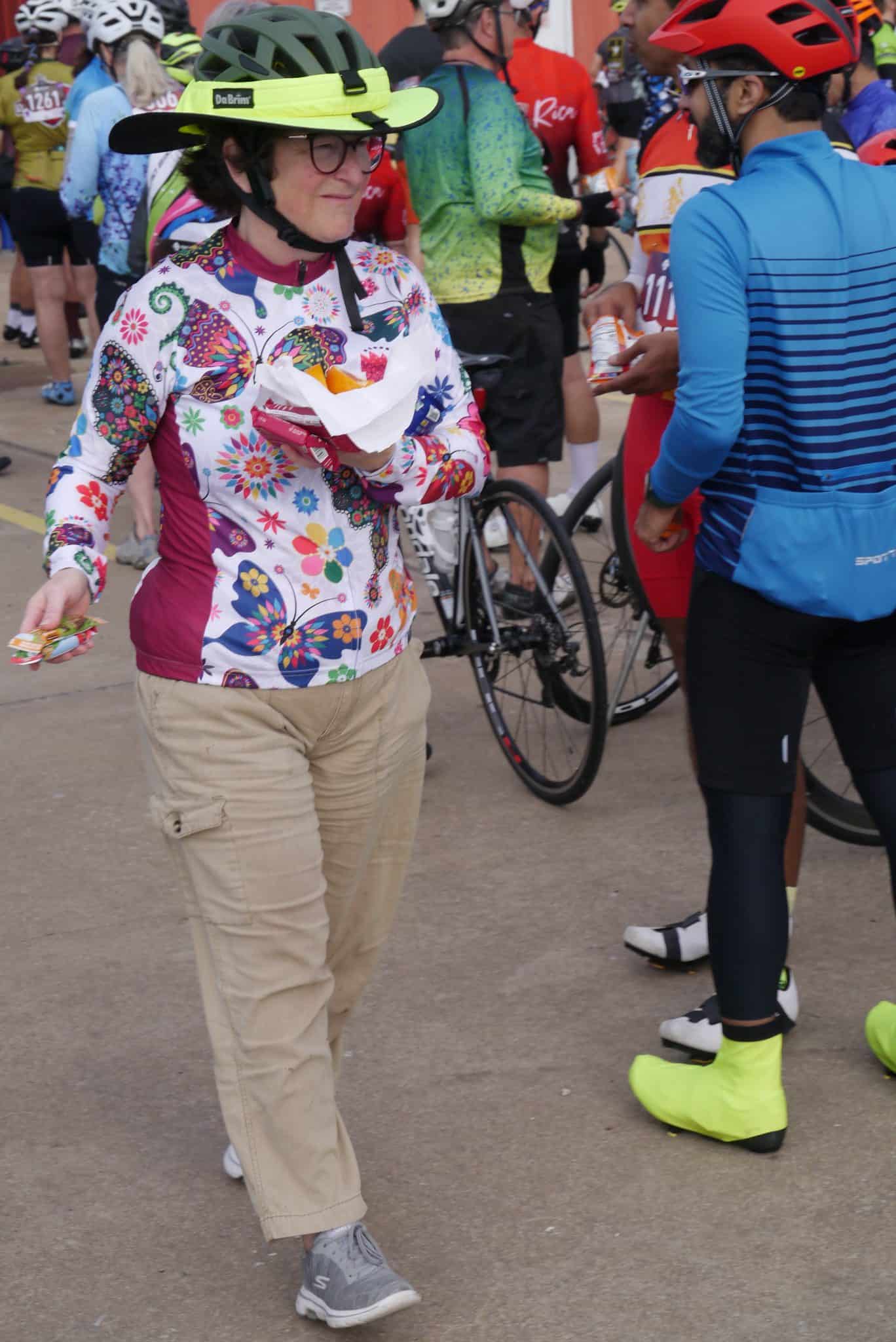 Colorful woman in butterfly jacket enjoying Bluebonnet Express cycling event.