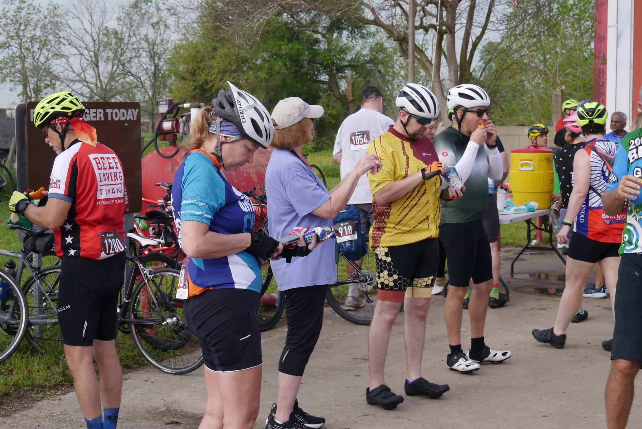 Cyclists at Bluebonnet Express race event, preparing and hydrating during the cycling competition.