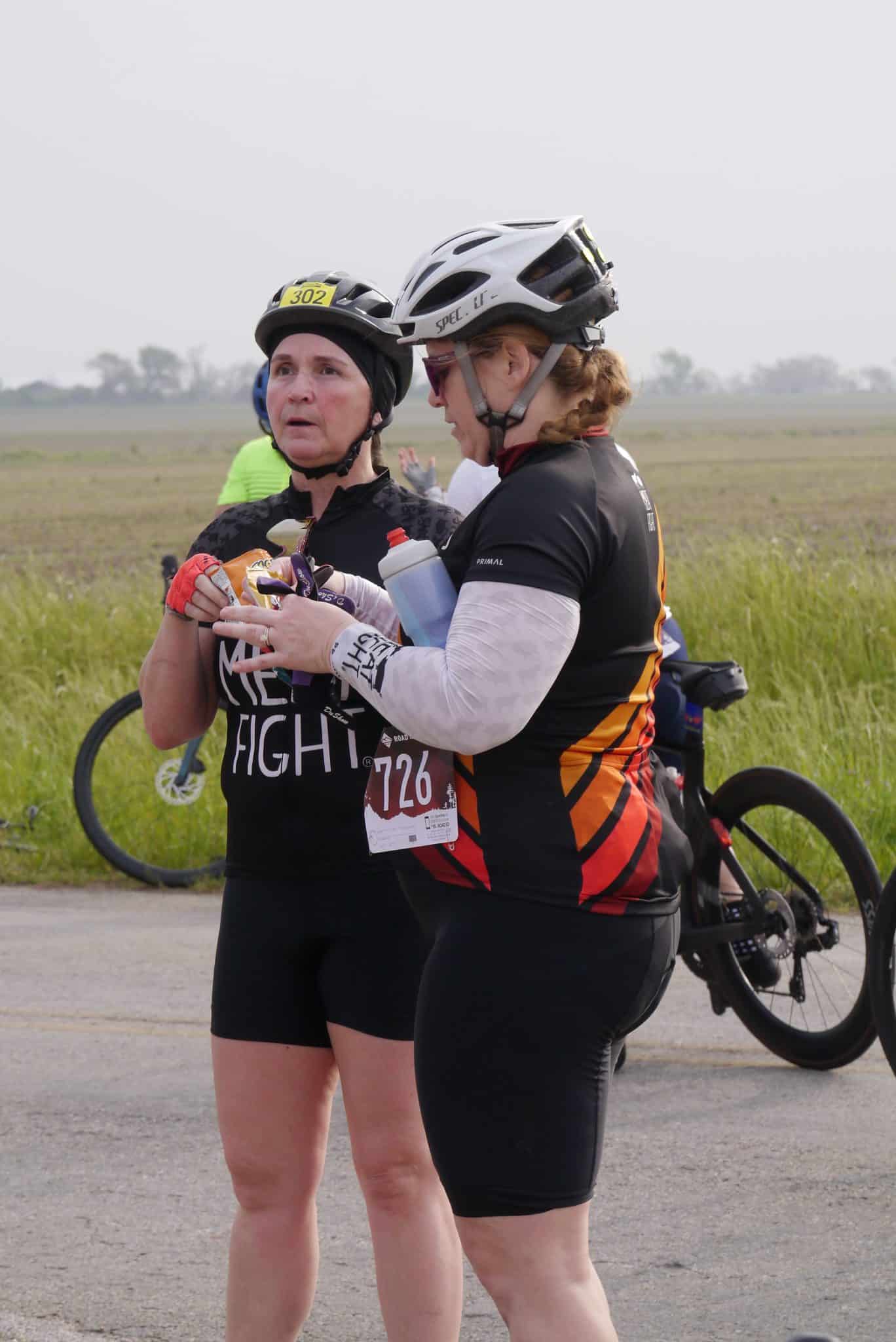 Cycling women sharing nutrition and support during Bluebonnet Express race.