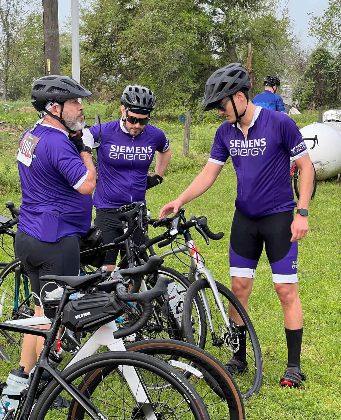Bike team wearing Siemens Energy jerseys during outdoor cycling event.