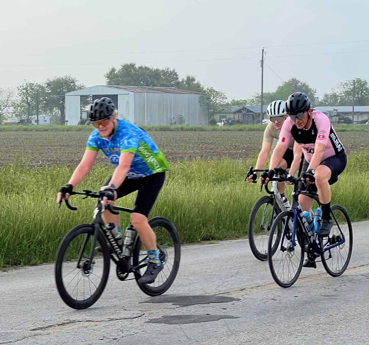 Energetic cyclists riding on a country road during a Bluebonnet Express event.