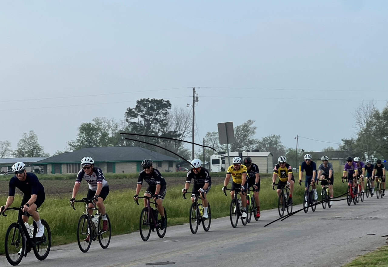 Cyclists riding together on a rural road, part of Bluebonnet Express cycling event, promoting outdoor fitness.