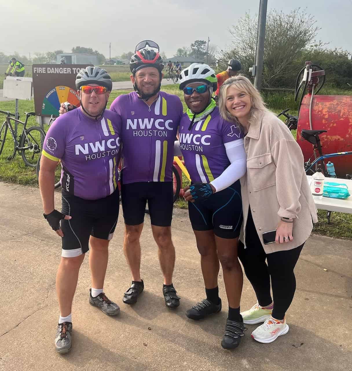 Colorful cycling team in purple NWCC Houston jerseys at Bluebonnet Express event.