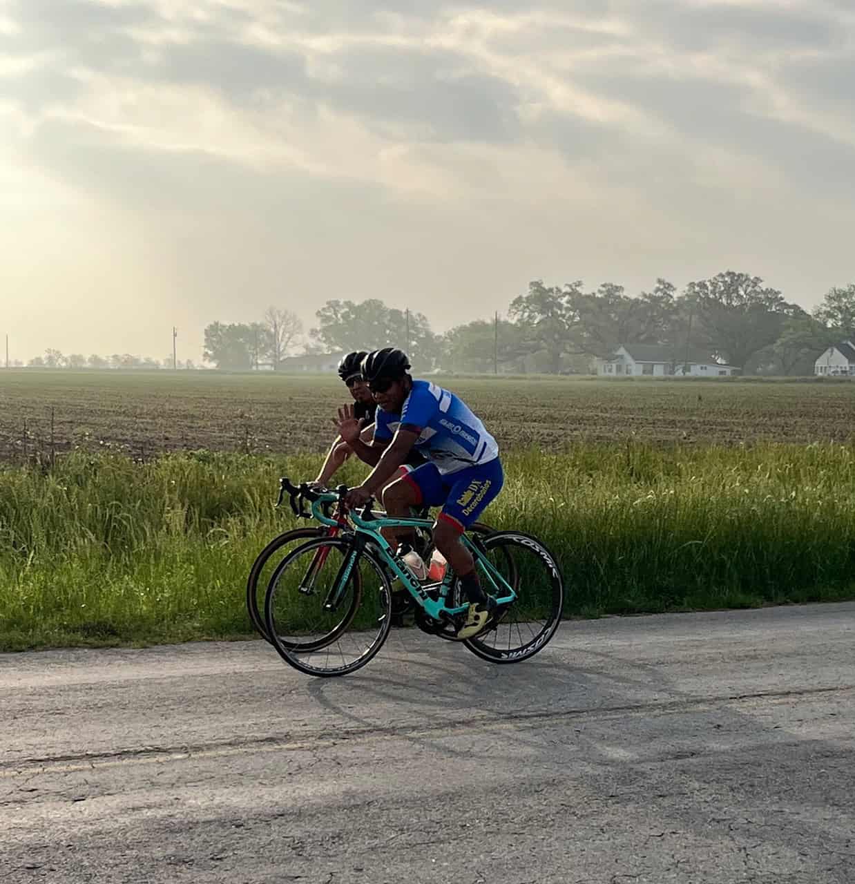 Energetic cyclists riding on scenic country road during the Bluebonnet Express event.