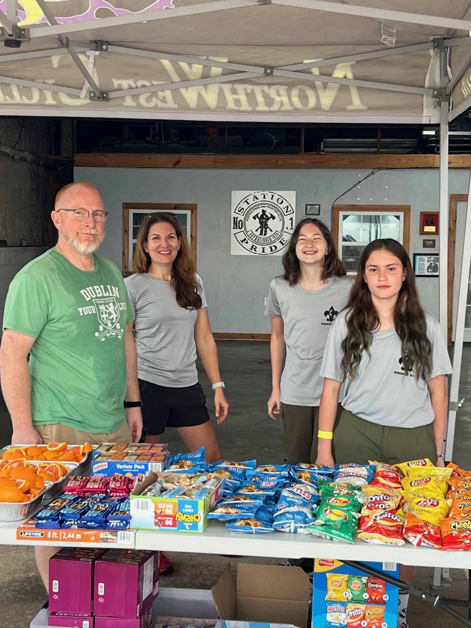 Bright blue bike-themed event at Bluebonnet Express with volunteers and snack tables.