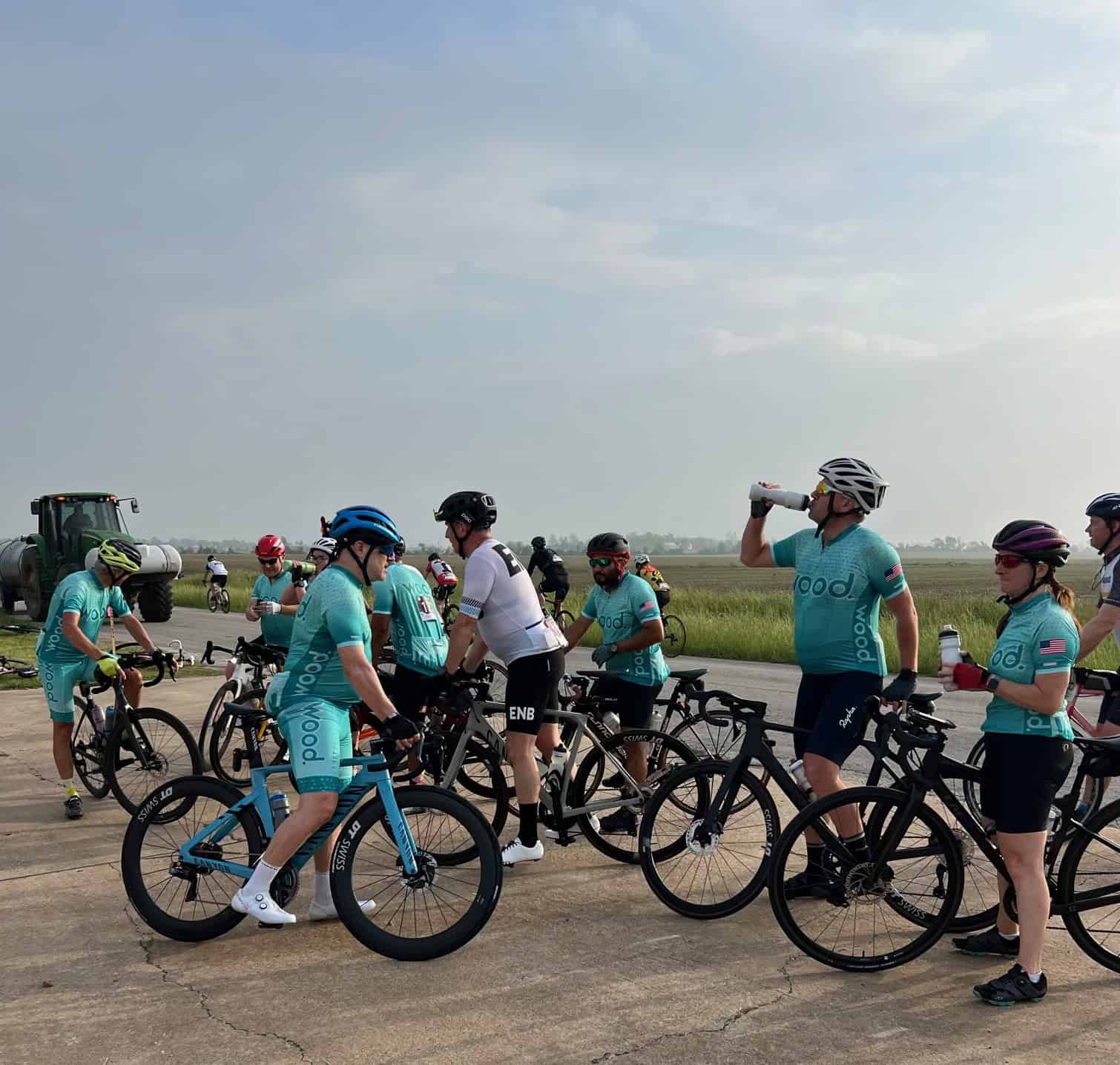Fast-paced group cycling in rural landscape, Bluebonnet Express event with cyclists in uniform.