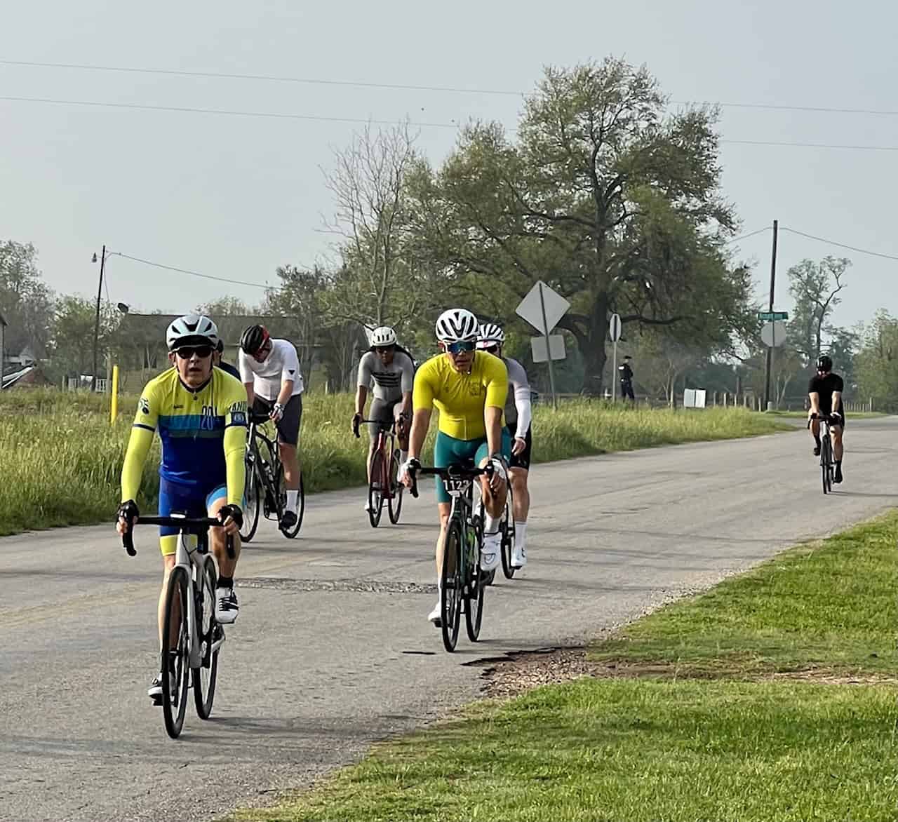 Riders participating in a cycling event on a rural road, promoting fitness and outdoor adventure.