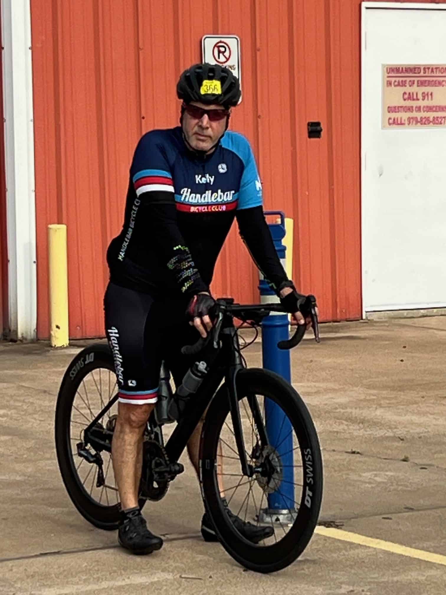 Rider in cycling jersey and helmet with bike at Bluebonnet Express, Texas bicycle shop.