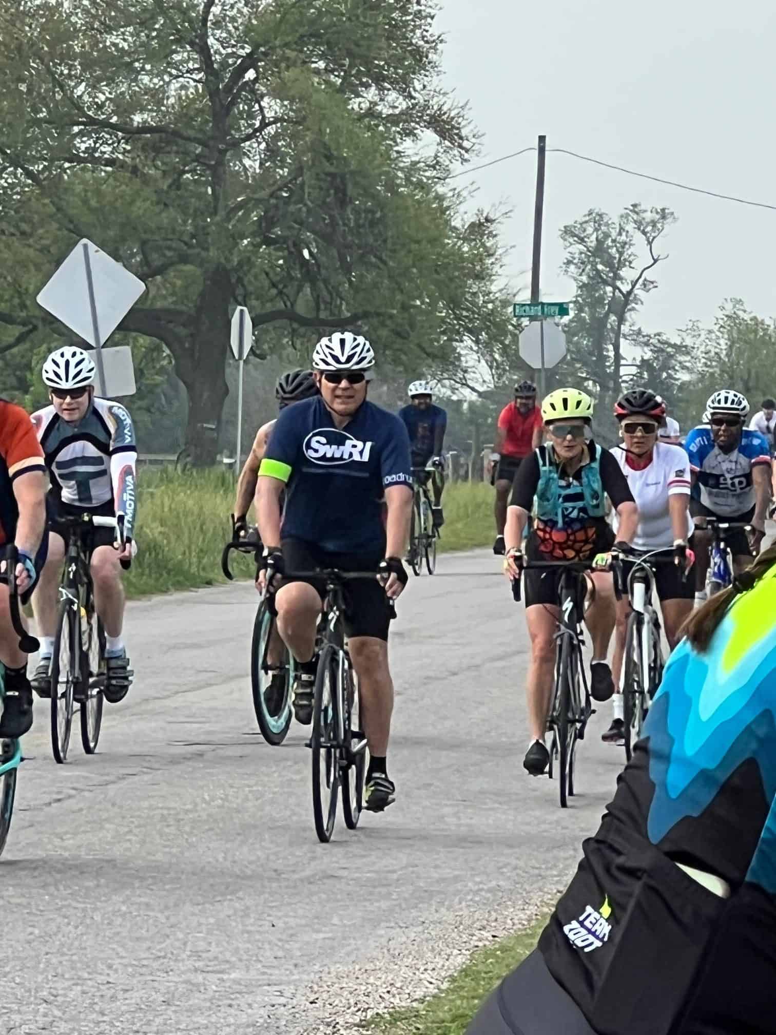 Cyclists participating in Bluebonnet Express cycling event on a scenic rural road.